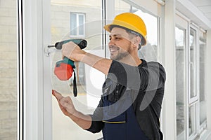 Construction worker using drill while installing window