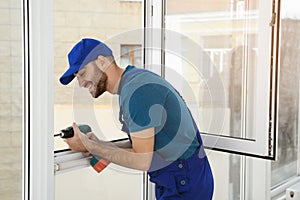 Construction worker using drill while installing window