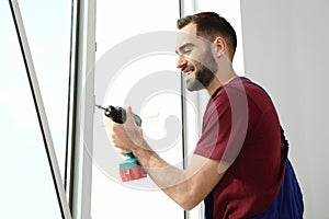 Construction worker using drill while installing window