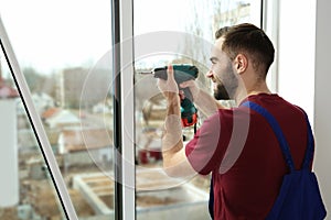 Construction worker using drill while installing window