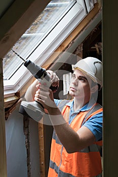 Construction Worker Using Drill To Install Replacement Window