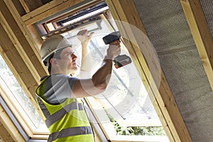 Construction Worker Using Drill To Install Window