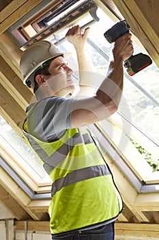 Construction Worker Using Drill To Install Window