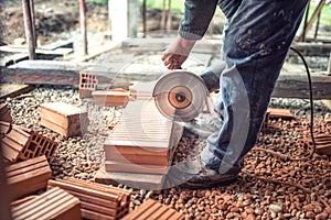 Construction worker using an grinder for cutting and sawing construction bricks