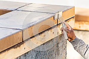 Construction Worker Using Hand Groover On Wet Cement Forming Coping Around New Pool