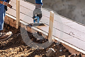 Construction Worker Using Hand Groover On Wet Cement Forming Coping Around New Pool