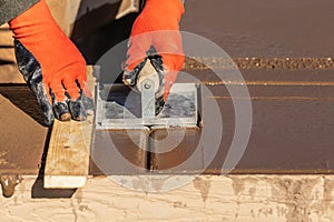 Construction Worker Using Hand Groover On Wet Cement Forming Coping Around New Pool