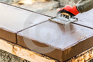 Construction Worker Using Hand Groover On Wet Cement Forming Coping Around New Pool