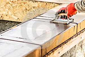 Construction Worker Using Hand Groover On Wet Cement Forming Coping Around New Pool