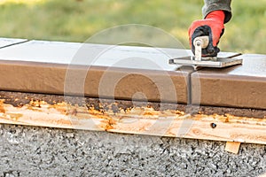 Construction Worker Using Hand Groover On Wet Cement Forming Coping Around New Pool