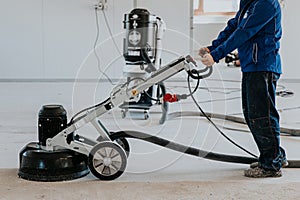 Construction worker using machine polishing surface floor smoothing and finishing hardener or epoxy concrete in the factory photo