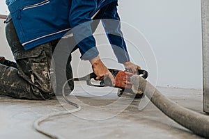 Construction worker using machine polishing surface floor smoothing and finishing hardener or epoxy concrete in the factory