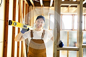 Construction Worker Using Power Tool in Unfinished Basement of New Home