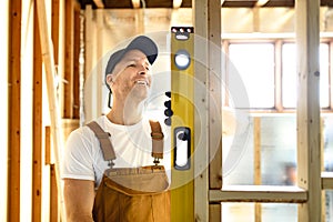 Construction Worker Using Power Tool in Unfinished Basement of New Home