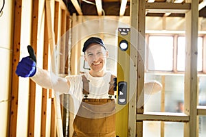 Construction Worker Using Power Tool in Unfinished Basement of New Home