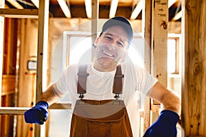 Construction Worker Using Power Tool in Unfinished Basement of New Home