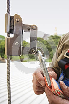 Construction worker using safety shock absorber lanyard with fall arrest, fall restraint harness protection device