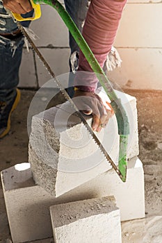 Construction worker using saw for cutting bricks
