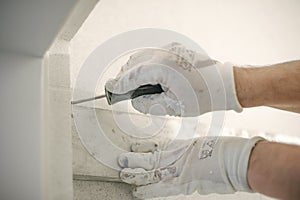 Construction worker using spirit level at home interior