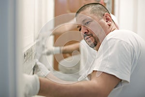 Construction worker using spirit level at home interior
