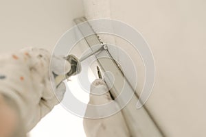 Construction worker using spirit level at home interior