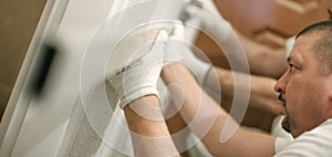 Construction worker using spirit level at home interior