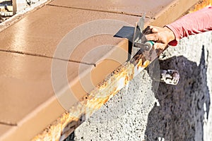 Construction Worker Using Stainless Steel Edger On Wet Cement Forming Coping Around New Pool