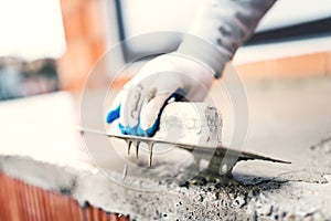 Construction worker using steel trowel for plastering