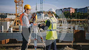Construction Worker Using Theodolite Surveying Optical Instrument for Measuring Angles in Horizont