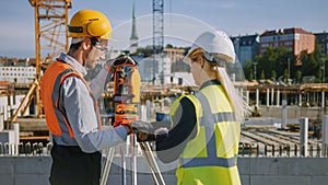 Construction Worker Using Theodolite Surveying Optical Instrument for Measuring Angles in Horizont