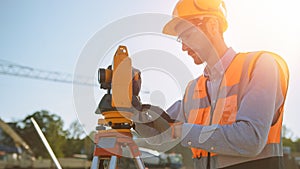 Construction Worker Using Theodolite Surveying Optical Instrument for Measuring Angles in Horizont