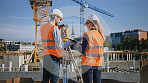 Construction Worker Using Theodolite Surveying Optical Instrument for Measuring Angles in Horizont