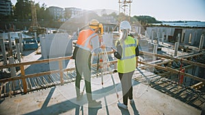 Construction Worker Using Theodolite Surveying Optical Instrument for Measuring Angles in Horizont