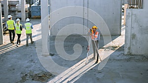 Construction Worker Using Theodolite Surveying Optical Instrument for Measuring Angles in Horizont