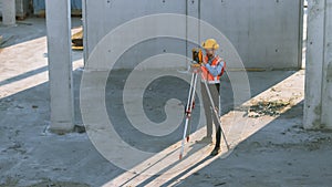 Construction Worker Using Theodolite Surveying Optical Instrument for Measuring Angles in Horizont