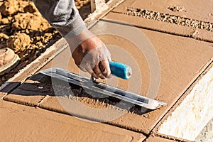 Laborer Using Trowel On Wet Cement Forming Coping Around New Pool photo