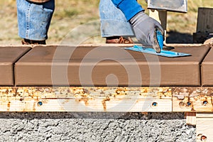 Construction Worker Using Trowel On Wet Cement Forming Coping Around New Pool