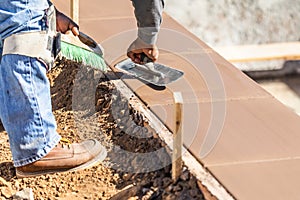 Construction Worker Using Trowel On Wet Cement Forming Coping Around New Pool