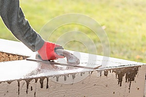 Construction Worker Using Wood Trowel On Wet Cement Forming Coping Around New Pool