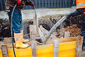 Construction worker vibrating cement on construction site.