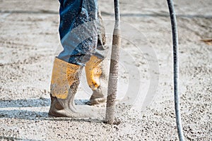 worker vibrating cement slab. Worker using concrete vibrator photo