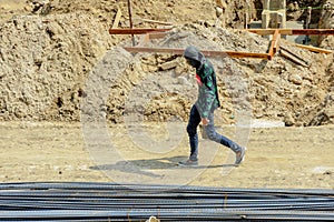 A construction worker walks hastily in the scorching sun.