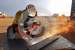 Construction worker wearing safety ears plug helmet, face shield, red welding leather glove protection