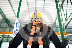 Construction worker wearing safety harness and safety line working at high place