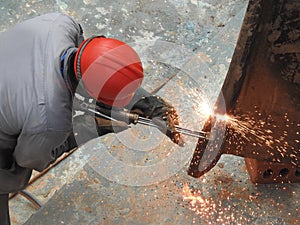 A construction worker is welding on the metal