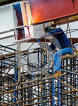 A Construction Worker welding steel bars.