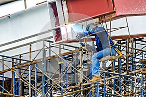 A Construction Worker welding steel bars.