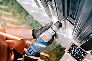 Construction worker working with an electric screwdriver on the construction site