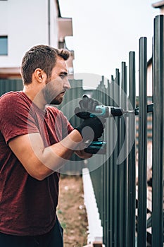 Construction worker working with an electric screwdriver on the construction site