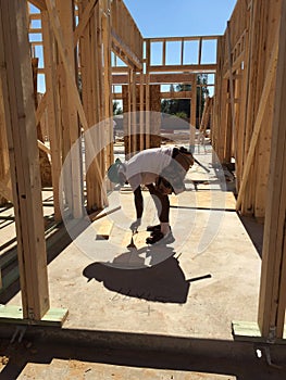 Construction worker working on the framing process for a new a house